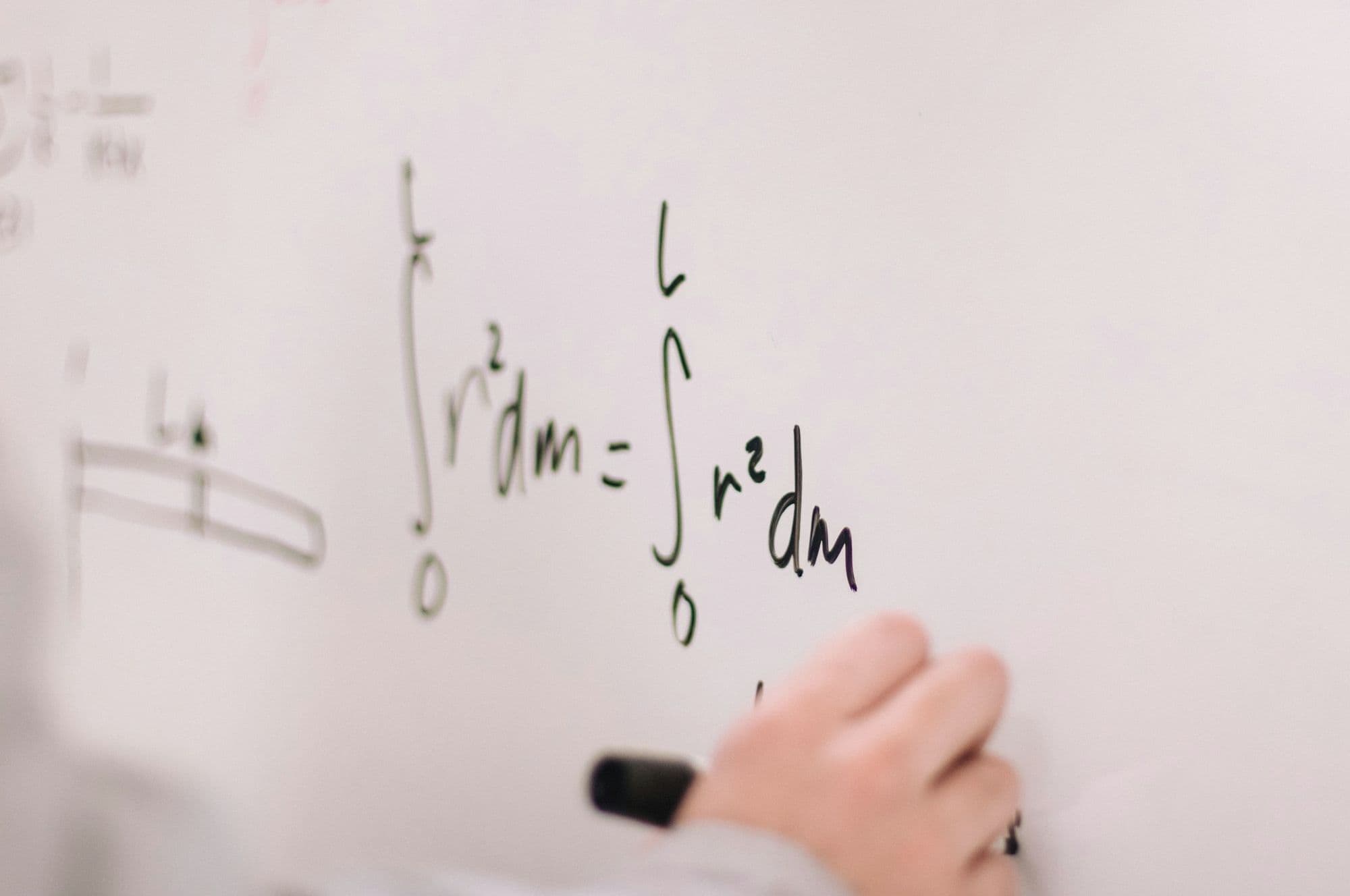 Tahtaya matematik formülü yazan öğrenci